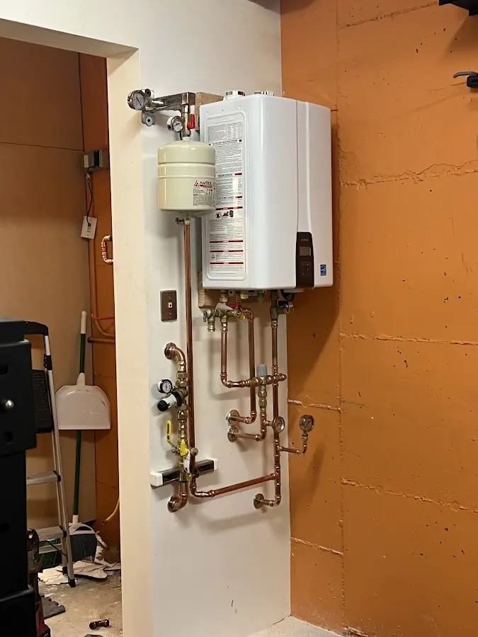 Plumbing technician inspecting water heater connections in Federal Way